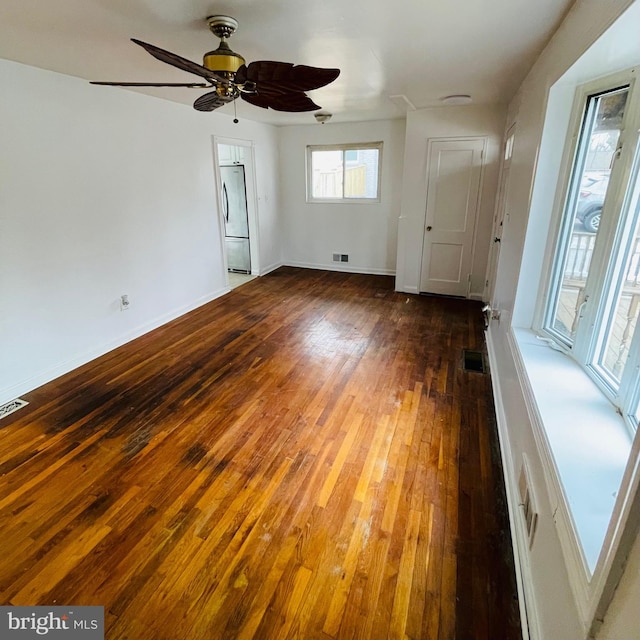 empty room with dark wood-type flooring and ceiling fan