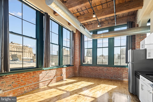 interior space with wood ceiling, rail lighting, and a city view