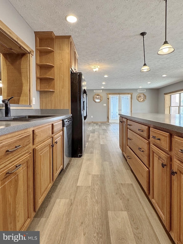 kitchen with decorative light fixtures, light wood-type flooring, stainless steel dishwasher, black fridge, and a textured ceiling