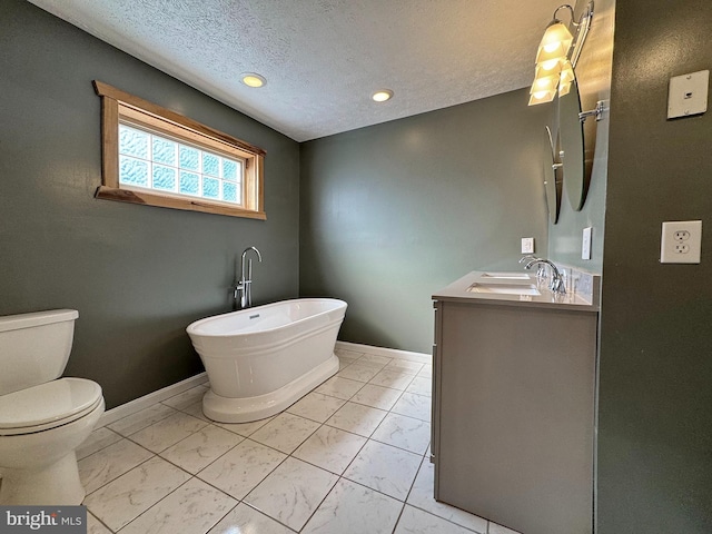 bathroom with vanity, a tub, a textured ceiling, and toilet