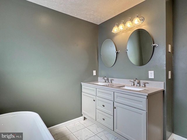 bathroom featuring vanity, a tub, and a textured ceiling