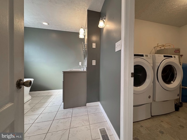 laundry room featuring washer and dryer and a textured ceiling