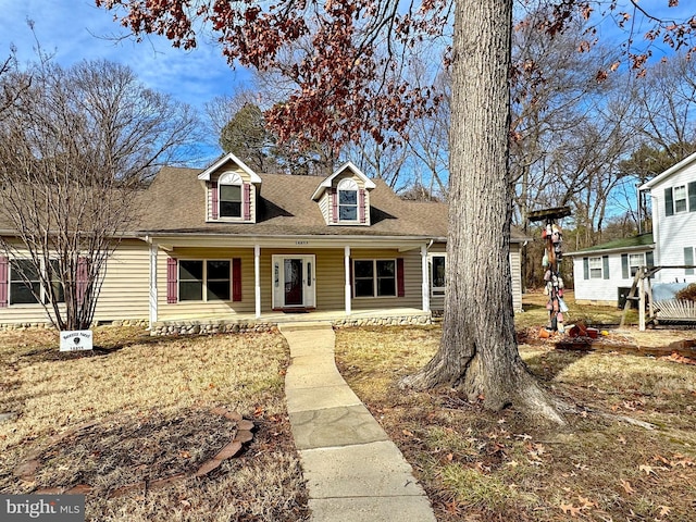 cape cod-style house featuring a porch and a front yard