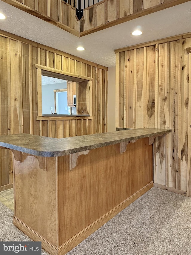 bar with light carpet and wood walls