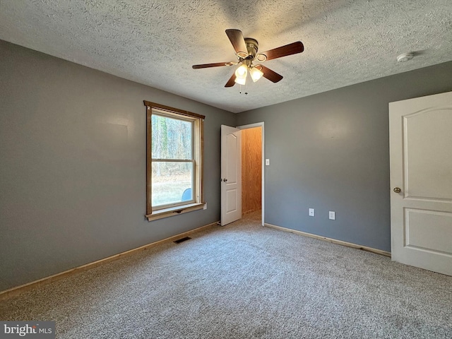 unfurnished bedroom featuring ceiling fan, carpet, and a textured ceiling