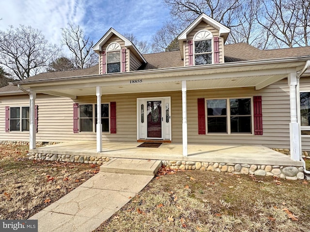 cape cod home featuring a porch