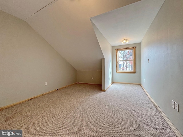 additional living space with vaulted ceiling and light colored carpet