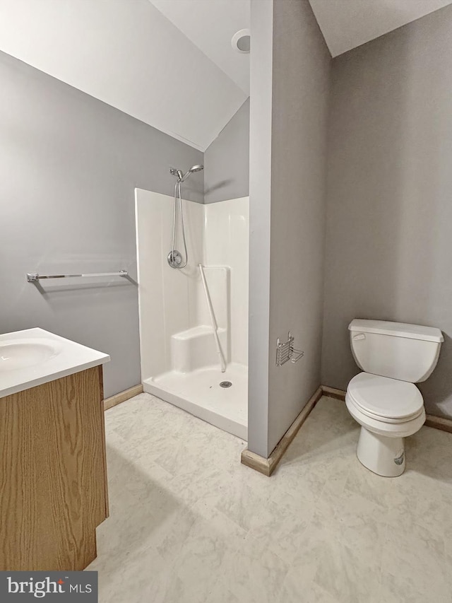 bathroom with lofted ceiling, vanity, toilet, and a shower