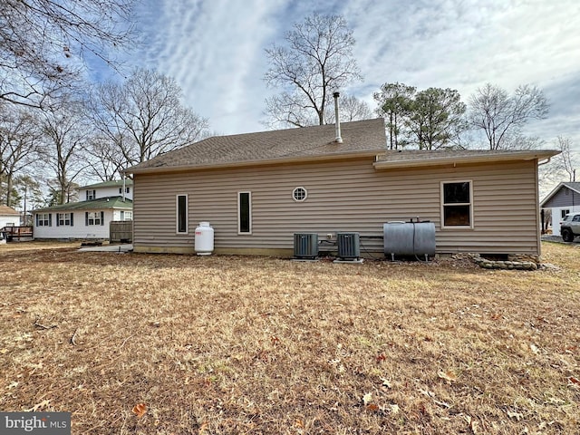 back of property with cooling unit and a lawn