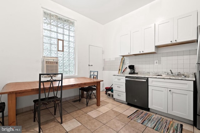 kitchen with sink, white cabinetry, black dishwasher, light stone counters, and tasteful backsplash