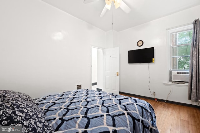 bedroom with cooling unit, hardwood / wood-style flooring, and ceiling fan