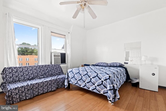 bedroom with hardwood / wood-style flooring, ceiling fan, and cooling unit