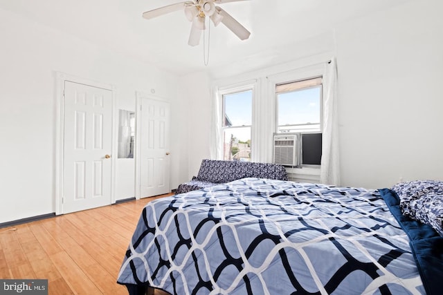 bedroom with cooling unit, hardwood / wood-style floors, and ceiling fan