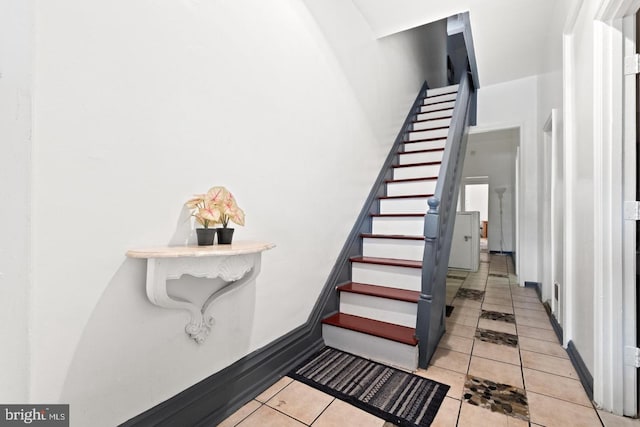 stairway with tile patterned floors