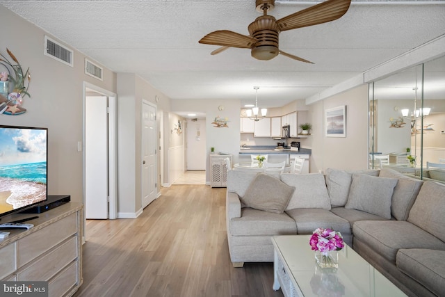10300 Coastal Hwy Unit 104, Ocean City, MD 21842 - living area with ceiling fan with notable chandelier, light wood finished floors, a textured ceiling, and visible vents