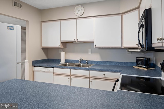 10300 Coastal Hwy Unit 104, Ocean City, MD 21842 - kitchen featuring black microwave, white dishwasher, a sink, white cabinets, and dark countertops