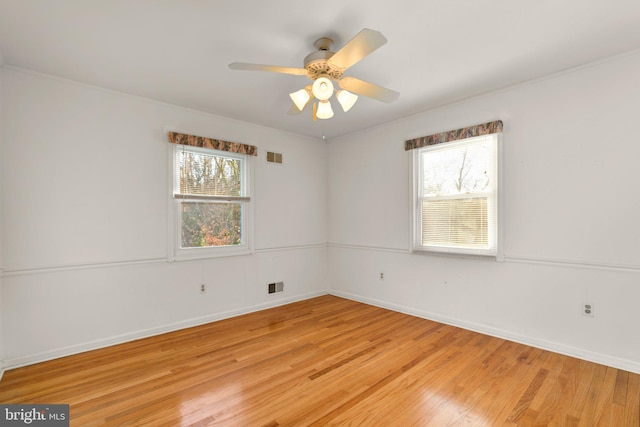 unfurnished room featuring ceiling fan, a wealth of natural light, and light wood-type flooring