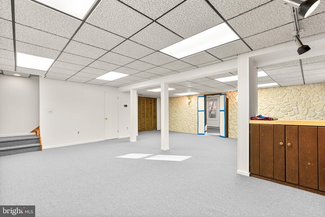 basement featuring light colored carpet and a drop ceiling