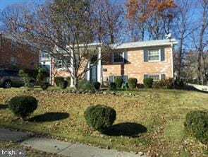 raised ranch featuring a front lawn