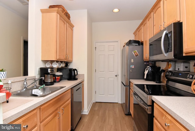 kitchen with stainless steel appliances, sink, light brown cabinets, and light wood-type flooring