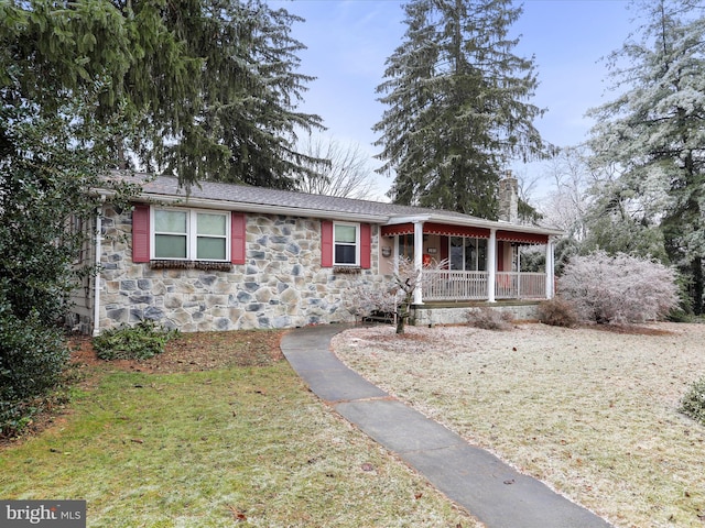 view of front of home with covered porch and a front lawn