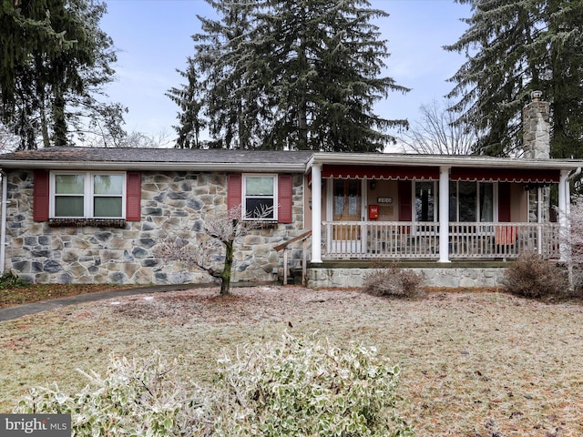 single story home featuring a porch and a front yard