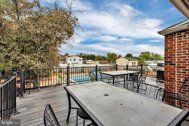 deck featuring area for grilling and a fenced in pool