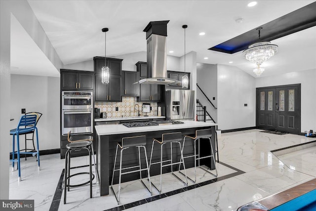 kitchen featuring stainless steel appliances, a kitchen island with sink, island range hood, and decorative light fixtures