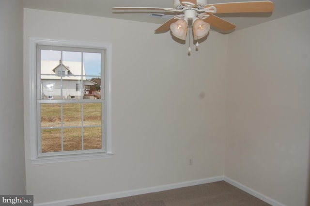 carpeted empty room with ceiling fan and baseboards