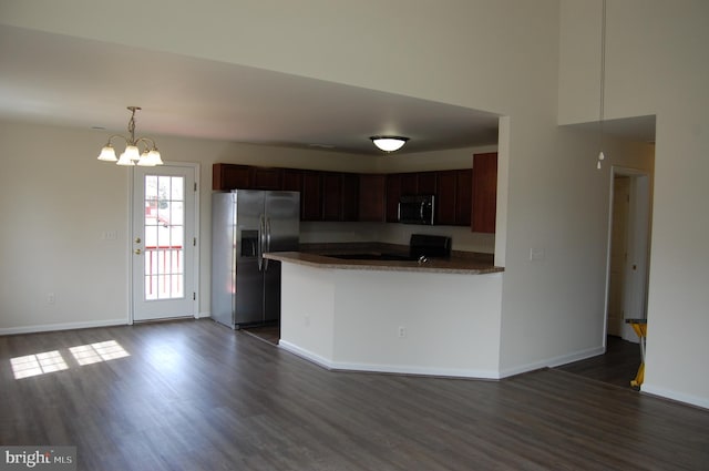 kitchen featuring a peninsula, baseboards, appliances with stainless steel finishes, and dark wood finished floors