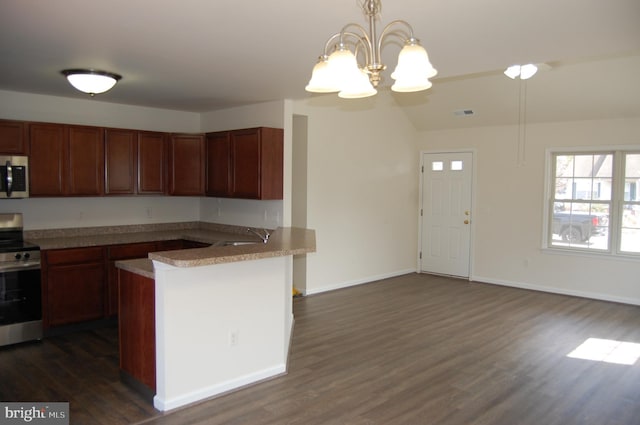 kitchen with dark wood-style floors, stainless steel appliances, a peninsula, and a sink