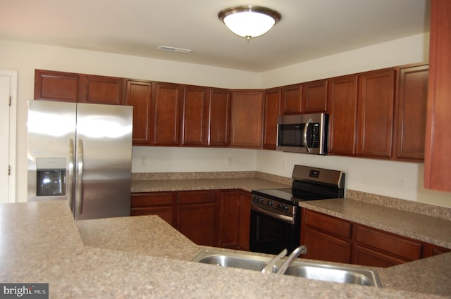 kitchen featuring visible vents, stainless steel appliances, a sink, and light countertops