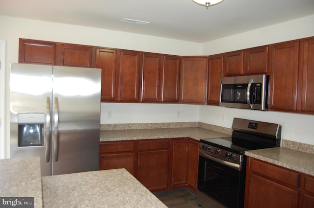 kitchen featuring stainless steel appliances, light countertops, and visible vents