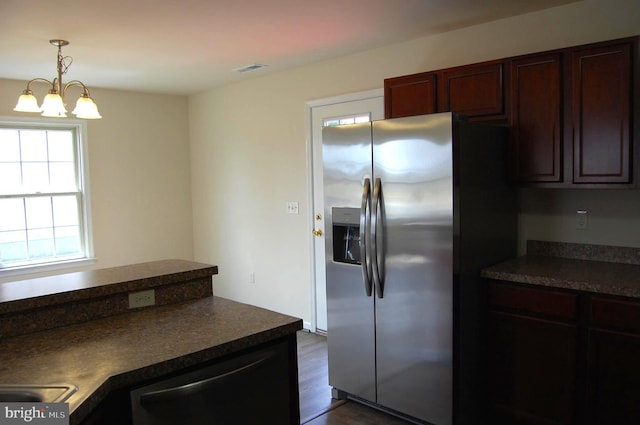 kitchen with dark wood-style flooring, stainless steel refrigerator with ice dispenser, dark countertops, visible vents, and dishwashing machine