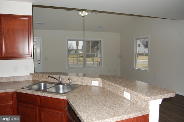 kitchen featuring light countertops, visible vents, a sink, and a peninsula