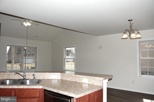 kitchen featuring visible vents, lofted ceiling, dishwashing machine, brown cabinets, and a sink