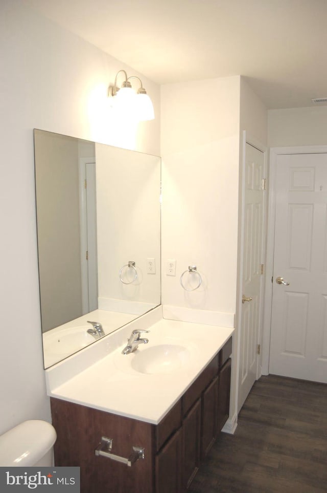 bathroom featuring visible vents, vanity, toilet, and wood finished floors