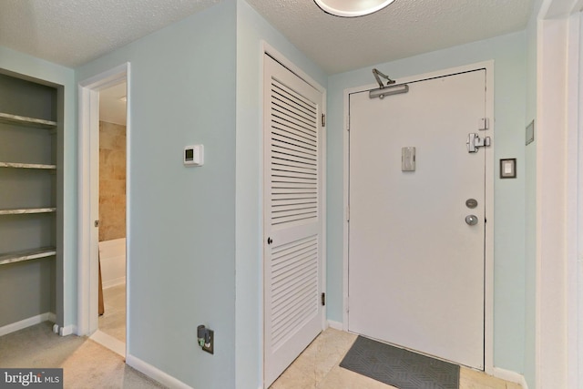 foyer entrance with a textured ceiling