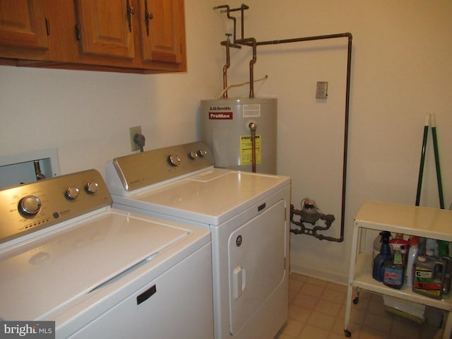 clothes washing area with cabinets, independent washer and dryer, and water heater