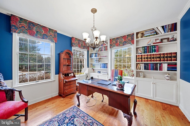 office with light wood-type flooring and a chandelier