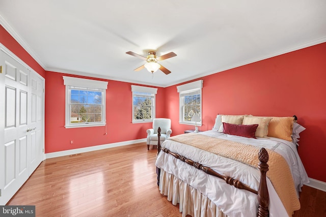 bedroom featuring light wood-type flooring, crown molding, and ceiling fan