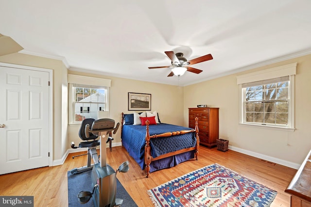 bedroom featuring multiple windows, crown molding, ceiling fan, and light hardwood / wood-style flooring