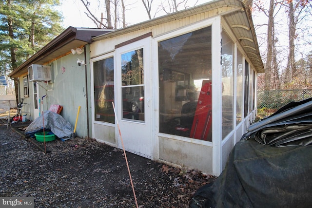 view of side of home featuring a sunroom and a wall mounted air conditioner