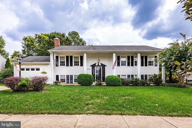 bi-level home featuring a garage and a front yard