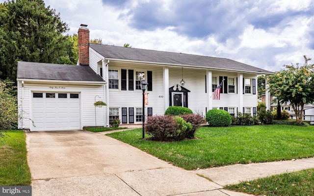 bi-level home featuring a garage and a front lawn