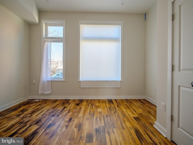 spare room featuring dark wood-type flooring and a wealth of natural light