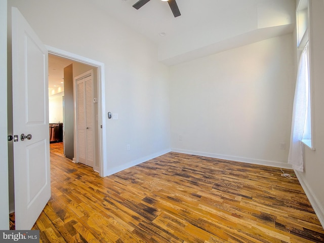 empty room featuring dark wood-type flooring and ceiling fan