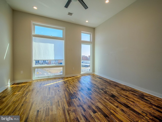 empty room featuring dark wood-type flooring and ceiling fan