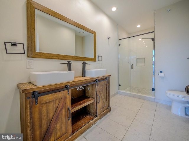 bathroom featuring vanity, a shower with shower door, and toilet