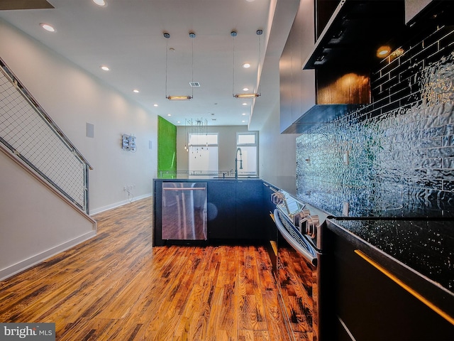 kitchen with sink, dishwasher, hanging light fixtures, hardwood / wood-style floors, and range with electric cooktop